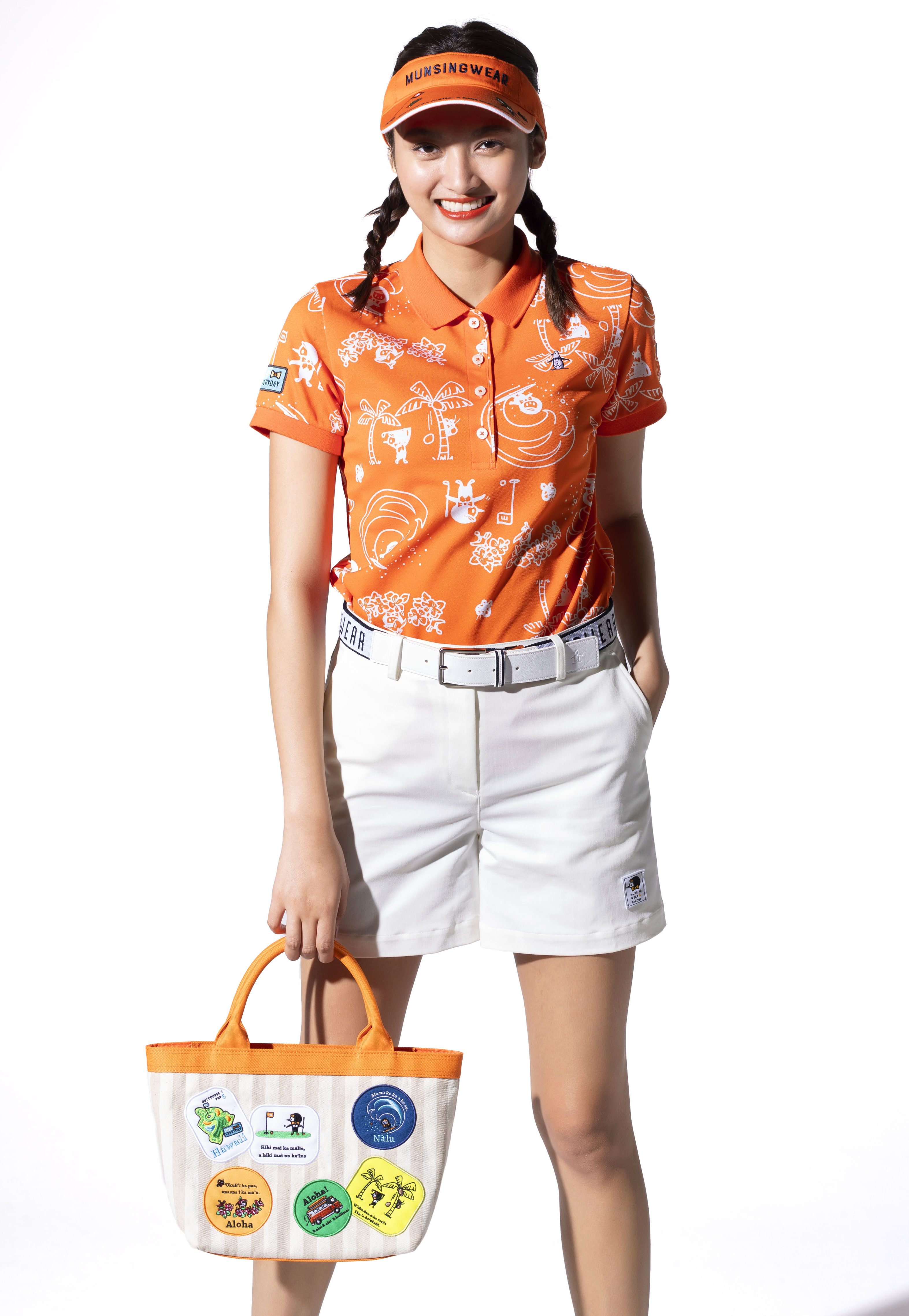 ハワイライフを楽しんでいるリトルピートが描かれた総柄シャツは、オレンジカラーで夏ならではの元気な着こなしに。ホワイトのショートパンツは後ろのポケットにもリトルピートの刺繍が施されていて、遊び心をON！　ポロシャツ￥18,000、ショートパンツ￥17,000、サンバイザー￥4,900、ベルト￥8,900 バッグ￥9,800（以上マンシングウェア／デサントジャパン）